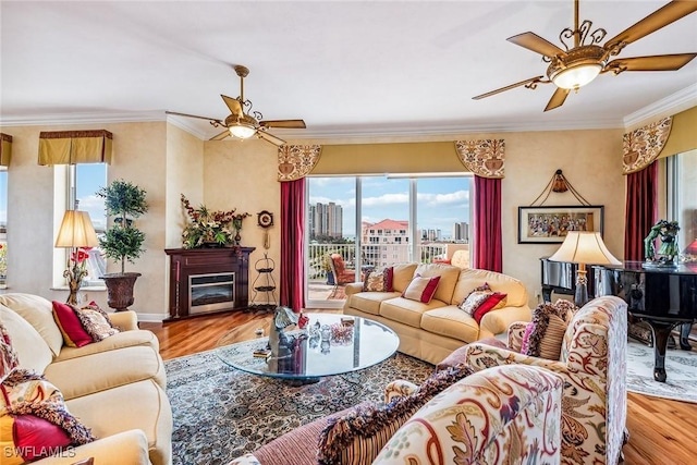 living room featuring ornamental molding, ceiling fan, and light wood-type flooring