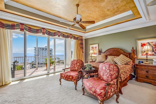 carpeted bedroom with access to outside, ceiling fan, a tray ceiling, crown molding, and a water view