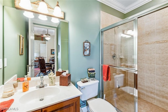 bathroom with ceiling fan, vanity, ornamental molding, a shower with shower door, and toilet