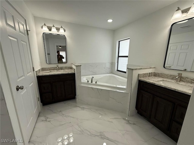 bathroom with a relaxing tiled tub and vanity