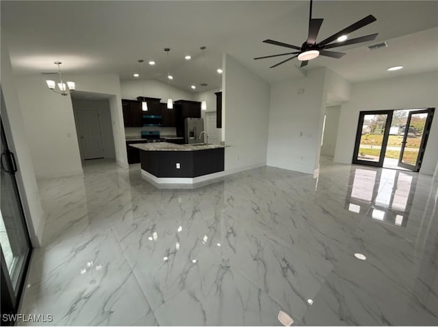 kitchen with extractor fan, light stone counters, decorative light fixtures, vaulted ceiling, and stainless steel appliances