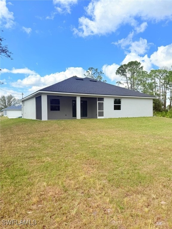 back of property featuring a lawn