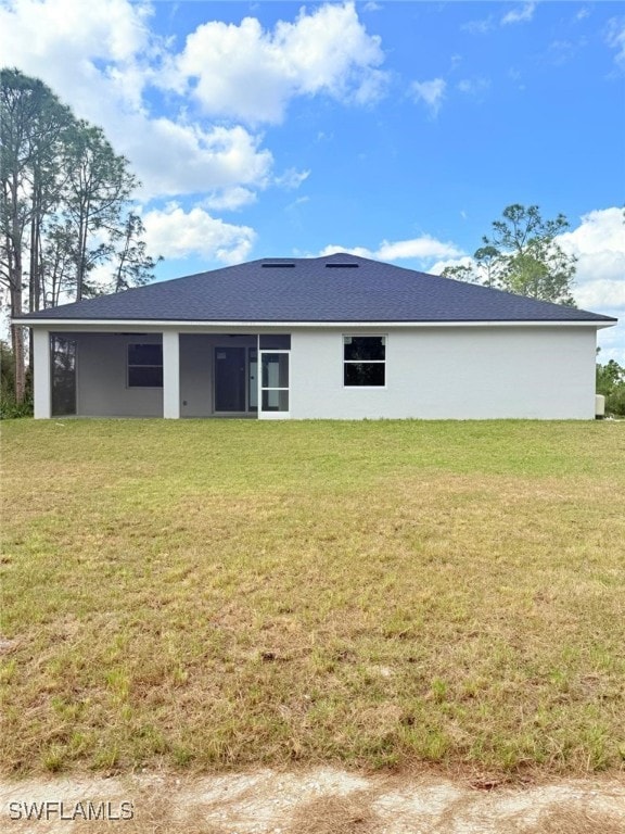 back of property featuring a lawn