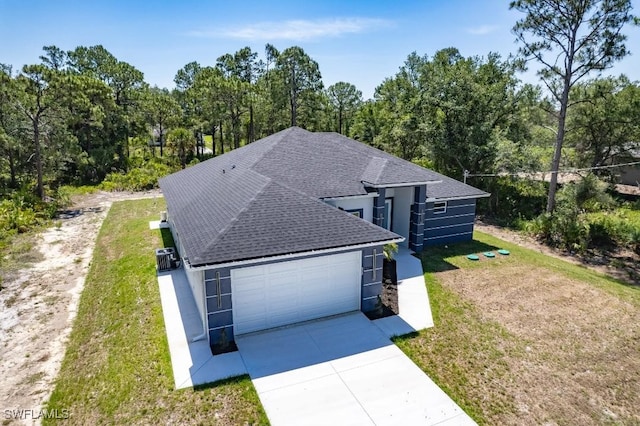 3702 Flora Ave N, Lehigh Acres, FL 33971 - view of front facade featuring a shingled roof, driveway, a front yard, and a garage