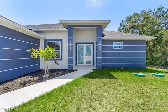 3702 Flora Ave N, Lehigh Acres, FL 33971 - view of front of property featuring french doors, a front lawn, stucco siding, and a shingled roof
