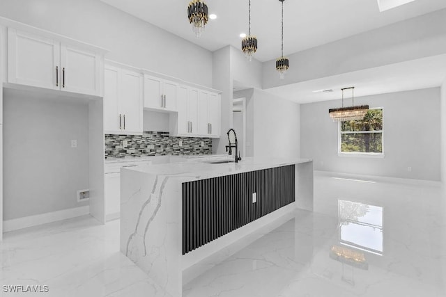 3702 Flora Ave N, Lehigh Acres, FL 33971 - kitchen featuring a sink, light marble finish flooring, white cabinetry, light stone countertops, and decorative backsplash
