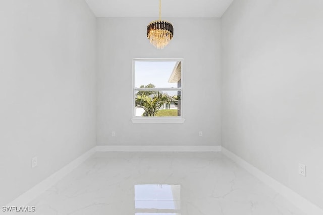 3702 Flora Ave N, Lehigh Acres, FL 33971 - unfurnished room featuring a chandelier, light marble finish flooring, and baseboards