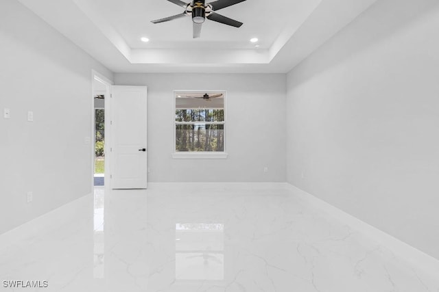 3702 Flora Ave N, Lehigh Acres, FL 33971 - empty room featuring marble tiled flooring, ceiling fan, a tray ceiling, and recessed lighting