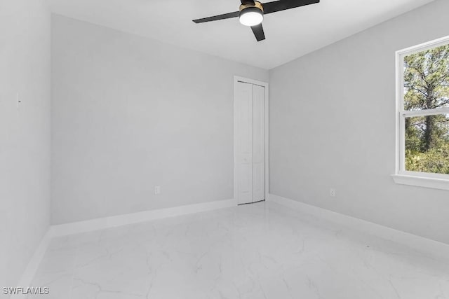 3702 Flora Ave N, Lehigh Acres, FL 33971 - unfurnished room featuring marble finish flooring, a ceiling fan, and baseboards