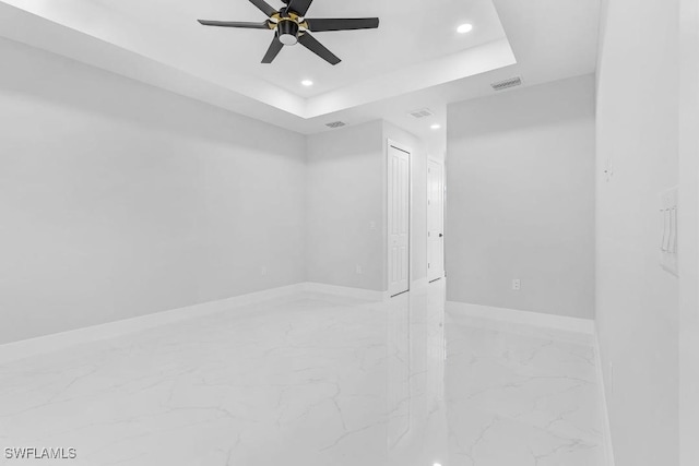 3702 Flora Ave N, Lehigh Acres, FL 33971 - unfurnished room with marble tiled flooring, recessed lighting, baseboards, ceiling fan, and a tray ceiling