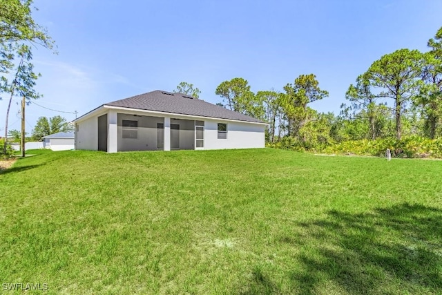 3702 Flora Ave N, Lehigh Acres, FL 33971 - rear view of property featuring a yard and stucco siding