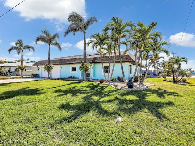 rear view of property featuring a garage and a lawn