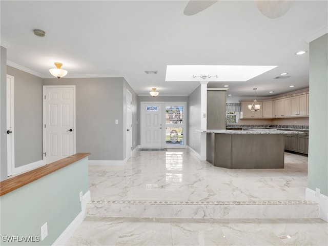 kitchen with hanging light fixtures, ornamental molding, a kitchen island, and a skylight