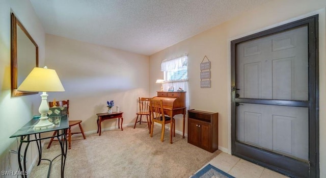 carpeted foyer entrance with a textured ceiling