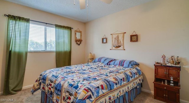 carpeted bedroom featuring ceiling fan and a textured ceiling