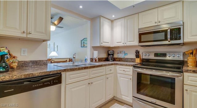 kitchen featuring ceiling fan, appliances with stainless steel finishes, sink, and white cabinets