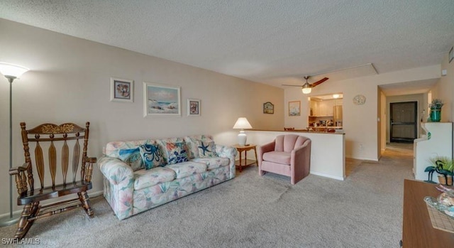 carpeted living room featuring ceiling fan and a textured ceiling