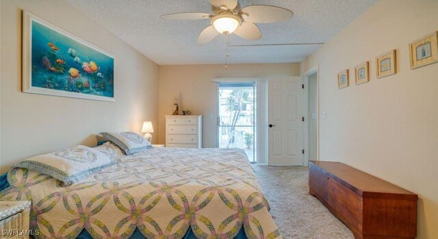 carpeted bedroom featuring ceiling fan and a textured ceiling