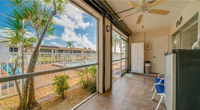 unfurnished sunroom featuring ceiling fan