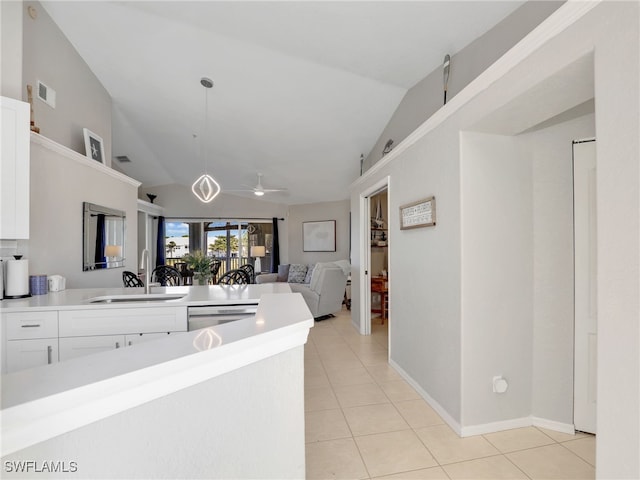 kitchen with light tile patterned flooring, dishwasher, sink, white cabinets, and hanging light fixtures