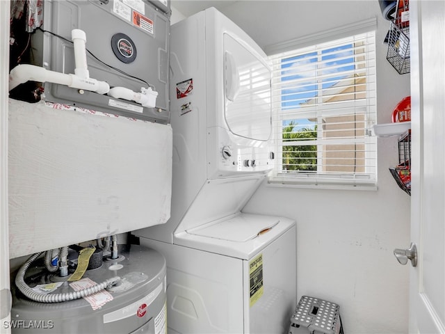 laundry room with water heater and stacked washing maching and dryer