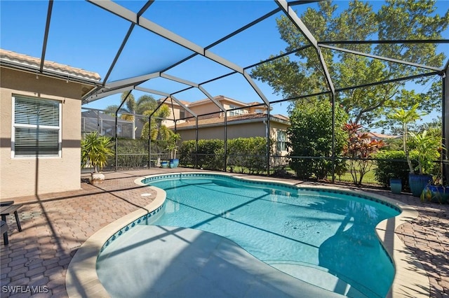 view of swimming pool featuring a patio and glass enclosure