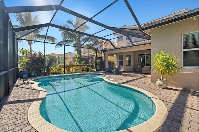 view of pool with a patio and glass enclosure