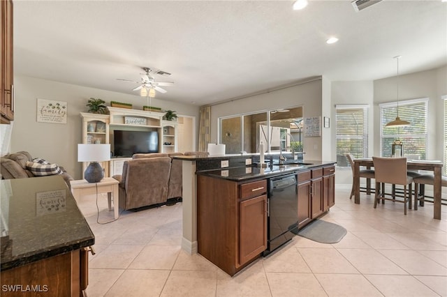 kitchen featuring dark stone countertops, sink, decorative light fixtures, and black dishwasher