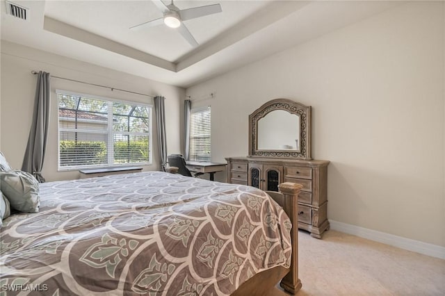 bedroom with ceiling fan and a tray ceiling