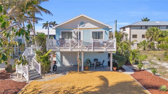 rear view of property featuring a garage, covered porch, and a patio area