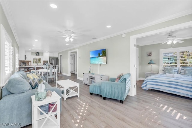 living room with crown molding, ceiling fan, and light hardwood / wood-style floors