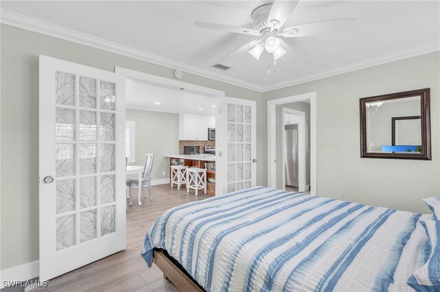 bedroom with ornamental molding, light hardwood / wood-style floors, and ceiling fan