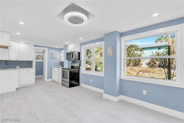 kitchen featuring tasteful backsplash, appliances with stainless steel finishes, sink, and white cabinets