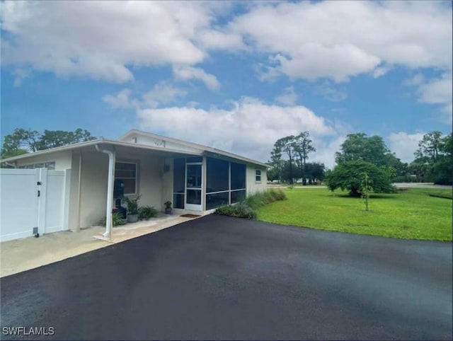 view of front of home featuring a sunroom and a front lawn