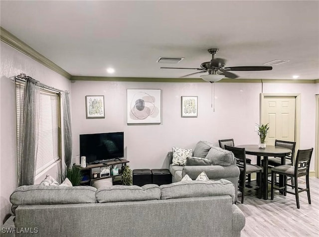 living room featuring ceiling fan, ornamental molding, and light hardwood / wood-style floors