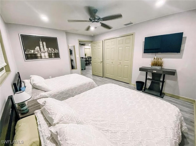 bedroom with hardwood / wood-style flooring, a closet, and ceiling fan