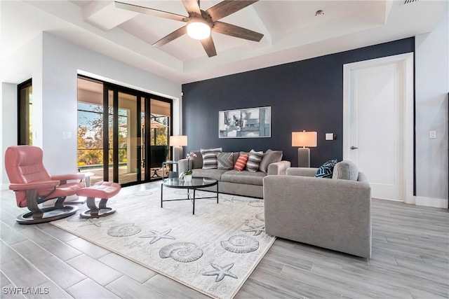 living room featuring ceiling fan and a tray ceiling