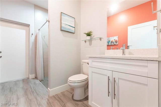 bathroom featuring walk in shower, vanity, toilet, and hardwood / wood-style flooring