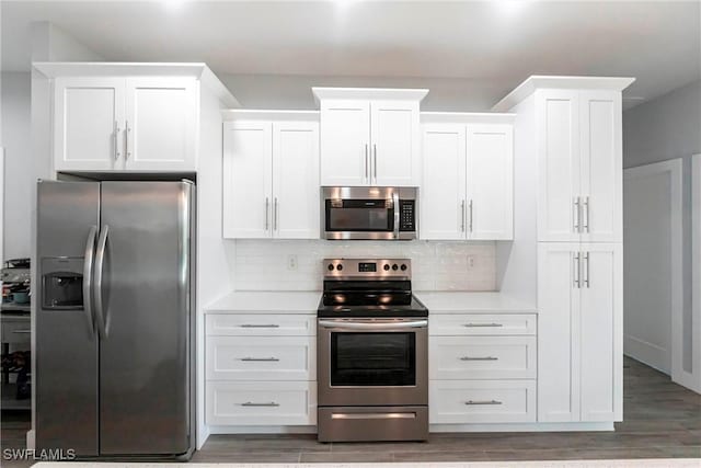 kitchen with white cabinetry, decorative backsplash, and stainless steel appliances