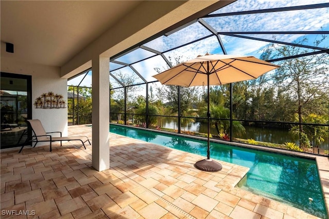 view of pool with a lanai, a patio area, and a water view