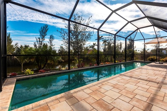 view of swimming pool featuring a patio and glass enclosure