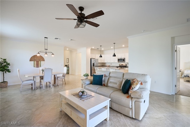 living room with ceiling fan, ornamental molding, and sink