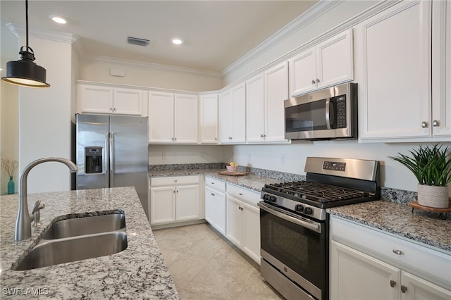 kitchen featuring appliances with stainless steel finishes, decorative light fixtures, sink, white cabinets, and light stone countertops