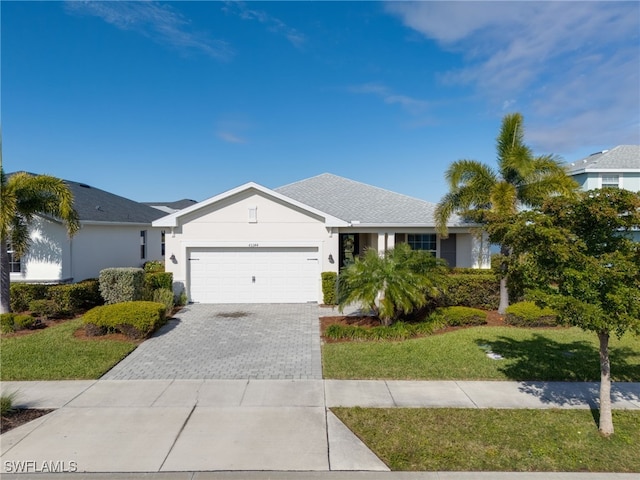 ranch-style home with a garage and a front lawn