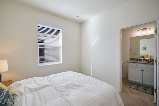 tiled bedroom with ensuite bathroom and sink