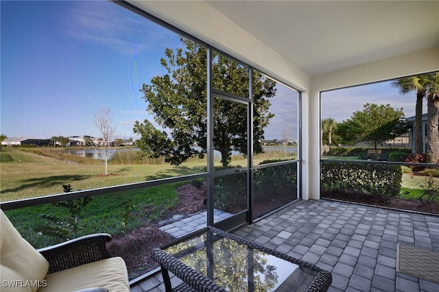 unfurnished sunroom featuring a water view