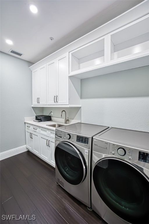 laundry area with sink, cabinets, washing machine and dryer, and dark hardwood / wood-style floors