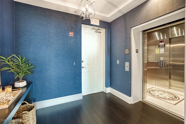 interior space featuring dark hardwood / wood-style floors, elevator, and an inviting chandelier