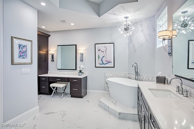 bathroom featuring a tub to relax in, vanity, and a notable chandelier