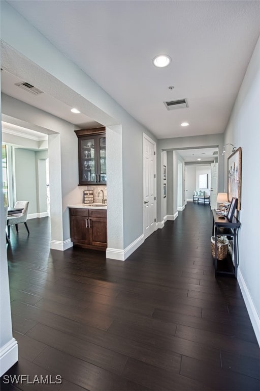 corridor featuring sink and dark wood-type flooring